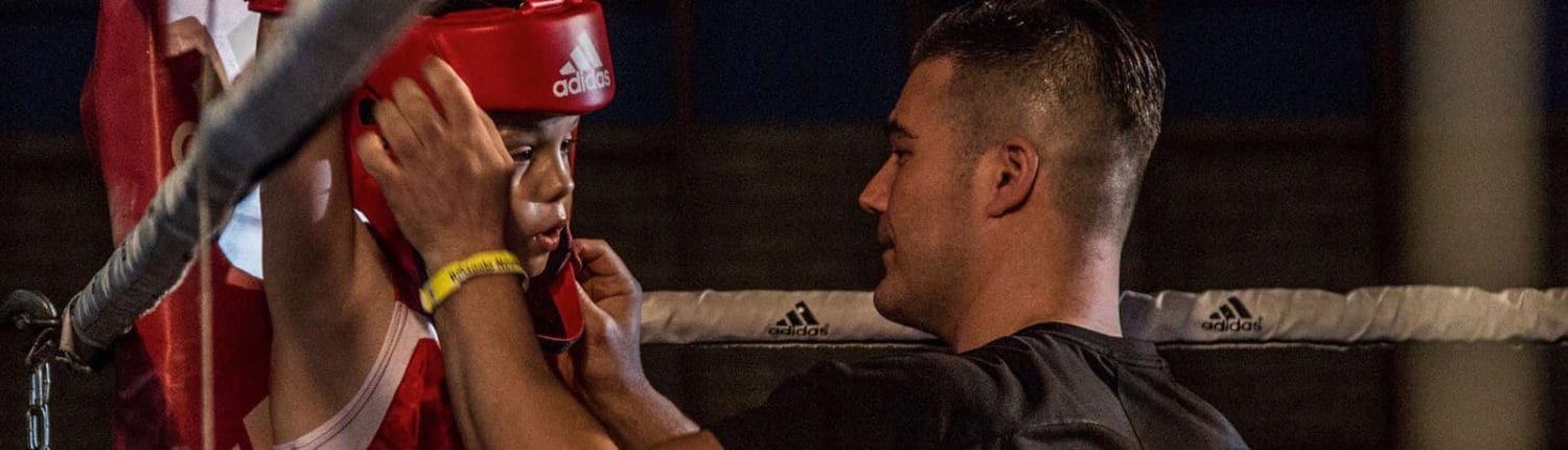 Coach begeleidt jonge bokser in de ring bij Boxing University – boksen Breda inschrijven voor veilige en professionele begeleiding.