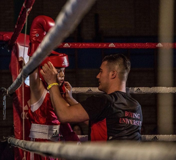 Boxing University Breda Coach begeleidt jonge bokser in de ring bij Boxing University – boksen Breda inschrijven voor veilige en professionele begeleiding.
