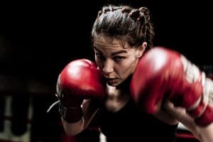 Meisje met bokshandschoenen in vechthouding tijdens bokstraining voor vrouwen bij Boxing University Breda – kracht en focus in beeld.