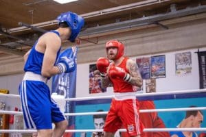Bokswedstrijd tijdens het Blue Light United Event met deelname van politieboksers, begeleid door gedelegeerde trainer Marcel van Boxing University Breda.